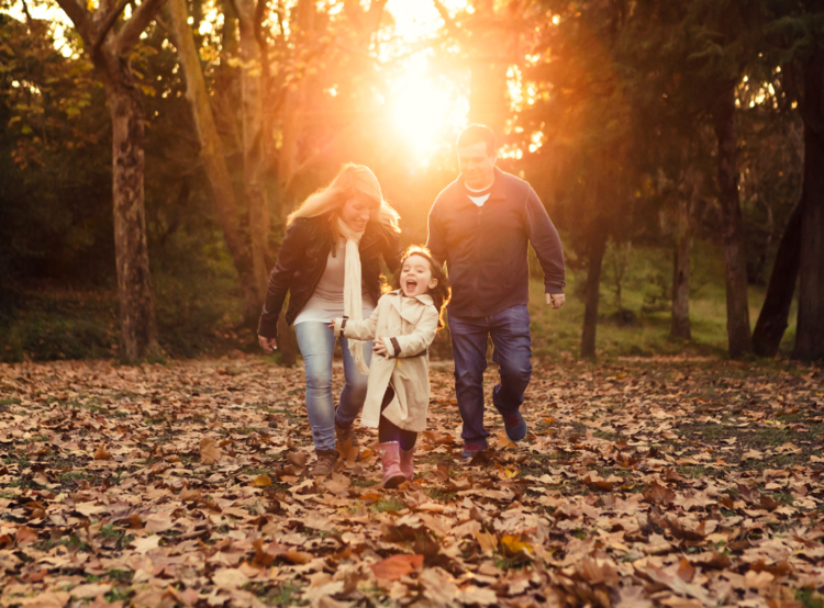 fall scenery with happy mom, dad and daughter